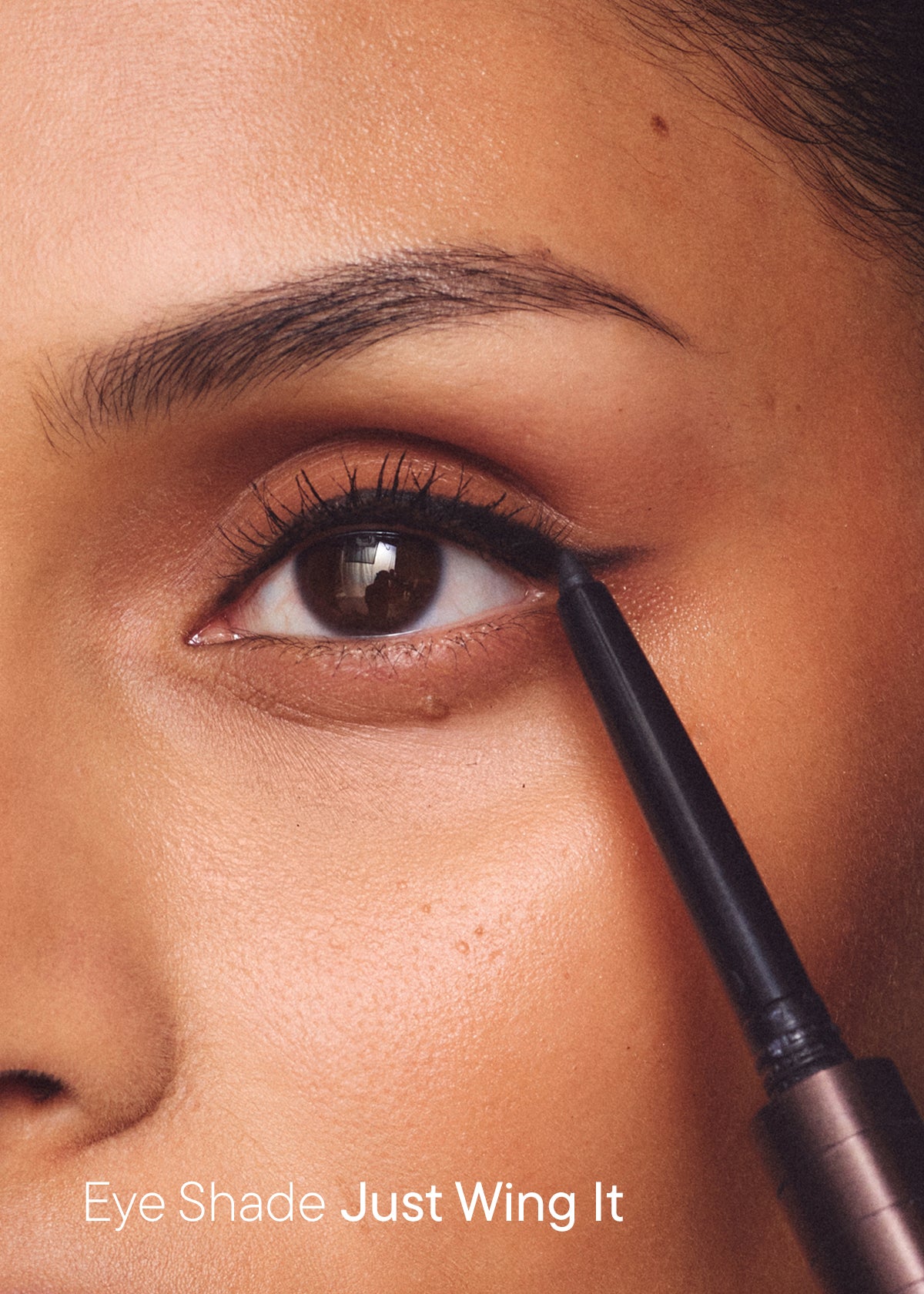 Winged eyeliner being applied with the pen, with the text "Eye Shade Just Wing It"