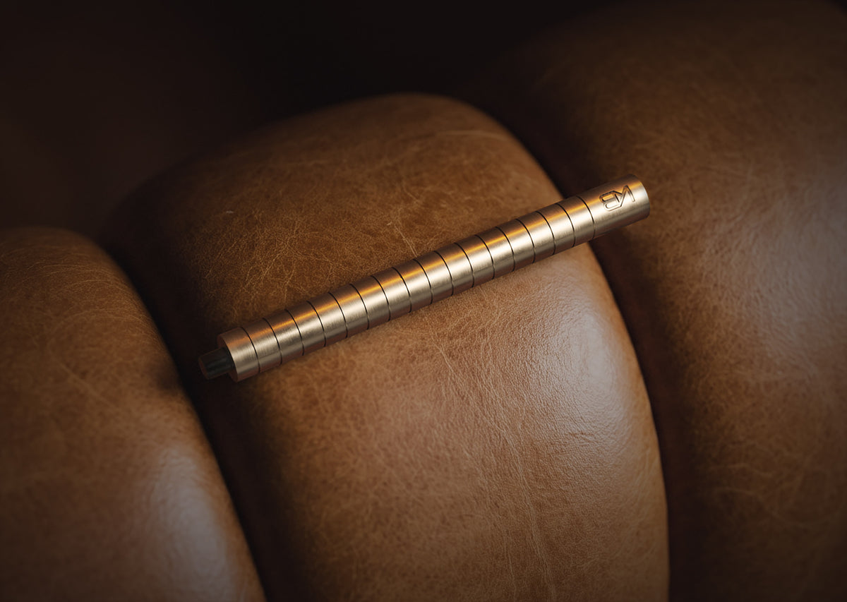 Karen Betts refillable pen in Champagne resting on tan leather