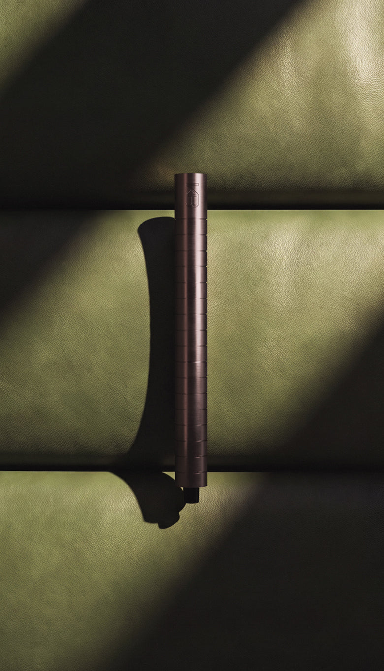 Karen Betts refillable pen in Rosewood standing on green leather in dramatic light