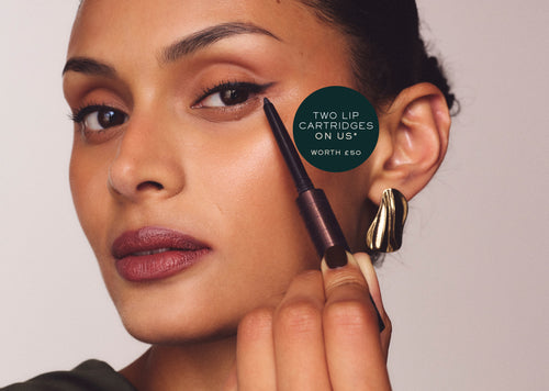 Woman drawing winged eyeliner with the pen, with a roundel reading "Two lip cartridges on us* – worth £50"