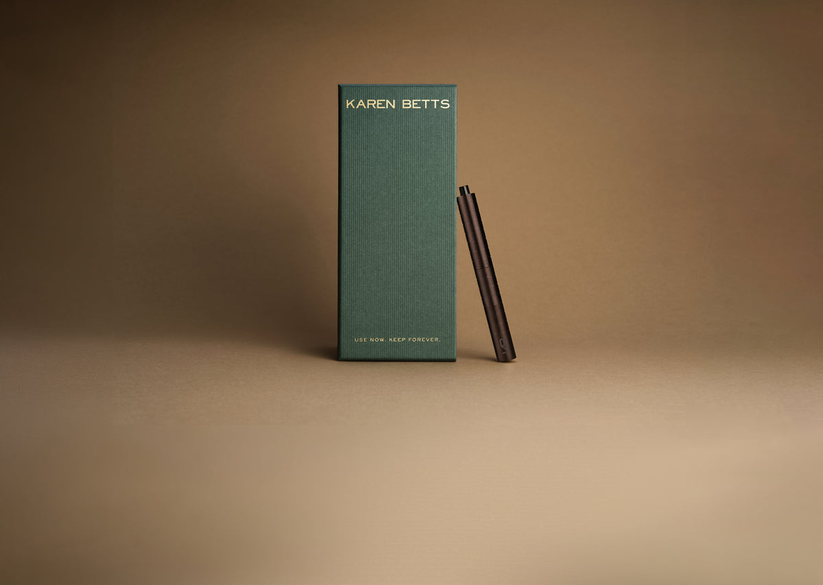 Green Karen Betts pen box printed "Use now. Keep forever." with the Chocolate pen leaning against it